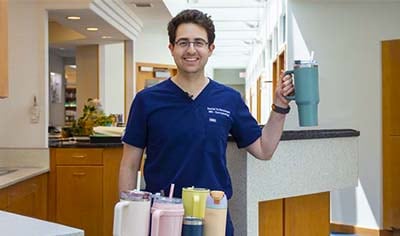 A Doctor Stands with a glass of water
