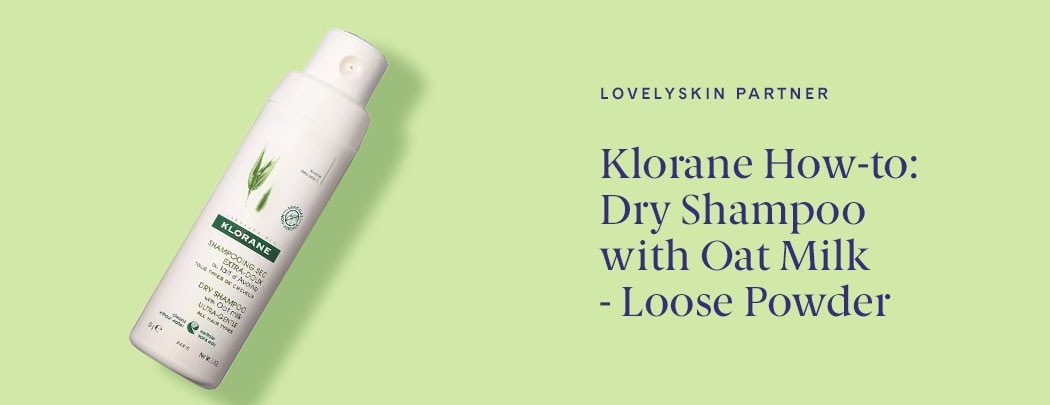 A bottle of Klorane dry shampoo on arranged on a green background.