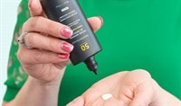 A woman with light to medium toned skin dispenses SkinCeuticals Future Mineral UV Defense Sunscreen SPF 50 into her palm.