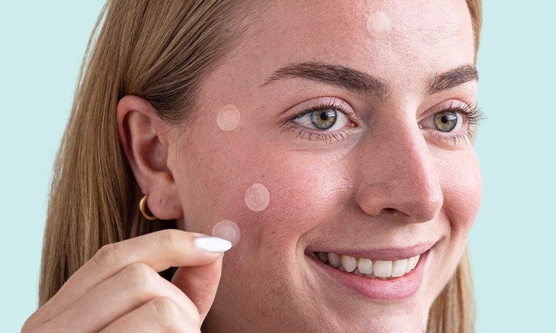 Woman applying blemish patches