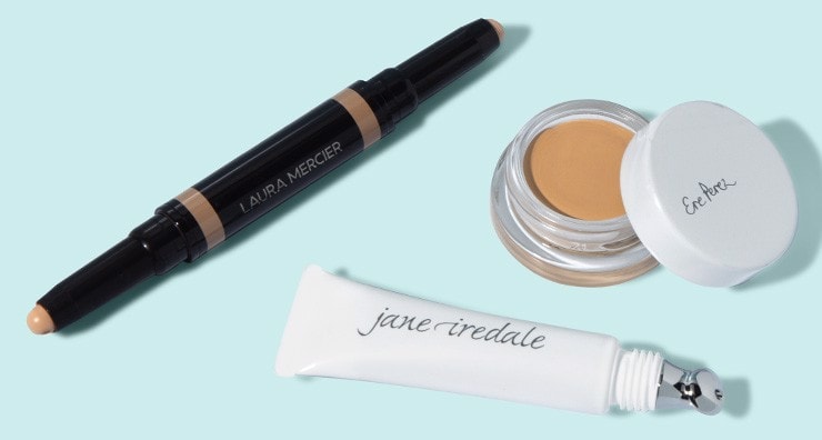 Concealers from Laura Mercier, Ere Perez and jane iredale on a light blue background