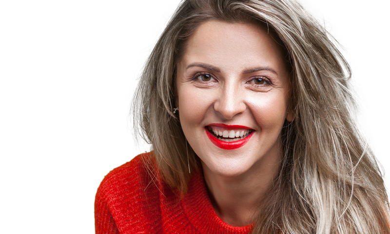 Woman in red sweater and red lipstick smiling