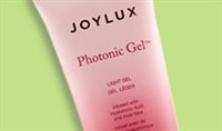 A tube of Joylux Photonic Gel™ sits over a green digital illustration.