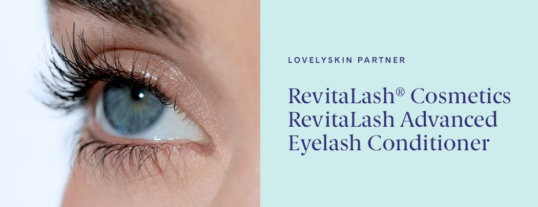 A person with fair skin and blue eyes gazes off into the distance. Their lashes are long, dark and curled.