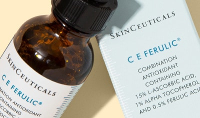 SkinCeuticals C E Ferulic serum bottle and box on a light yellow background with soft shadows