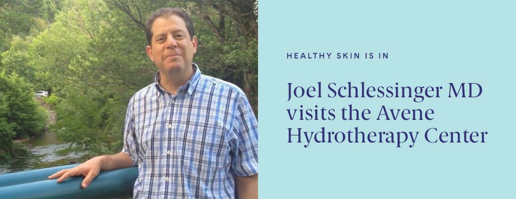 Dr. Joel Schlessinger stands over a stream while smiling.