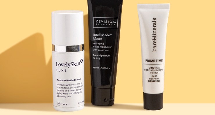 A bottle of LovelySkin LUXE retinol serum and tubes of bareMinerals and Revision Skincare primers on a gold background.