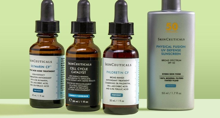 Bottles of SkinCeuticals serums and sunscreen standing up in front of a light green background