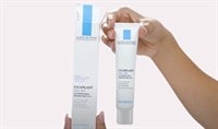 Two hands holding a tube of La Roche-Posay Cicaplast Gel B5 Skin Protectant and its carton in the other.
