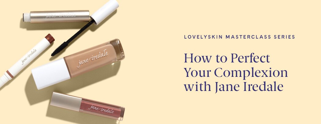 A gold mascara tube lays next to a white eyeshadow stick, a bottle of liquid foundation and a rose-colored lip gloss.