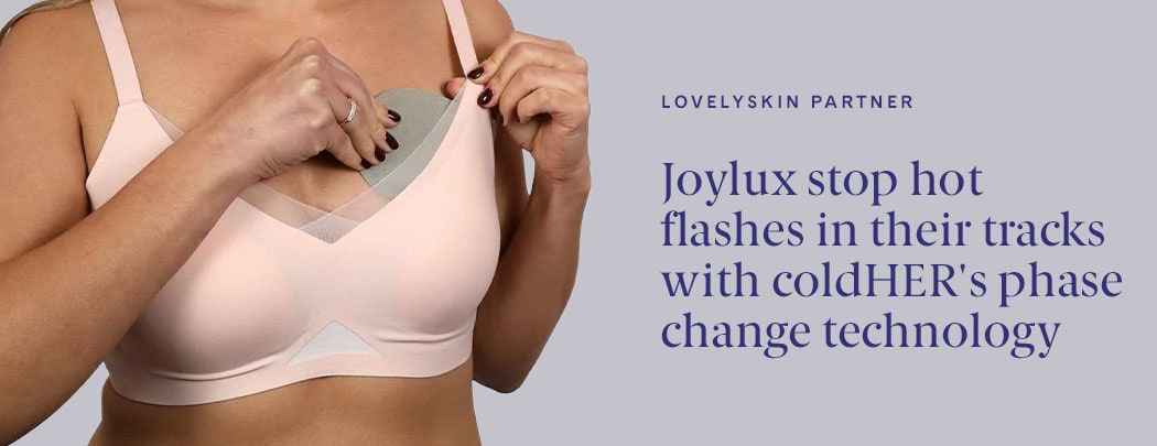 A person wearing a soft pink bra and a medium skin tone holds a Joylux coldHER Cooling Bra Insert over their breast.