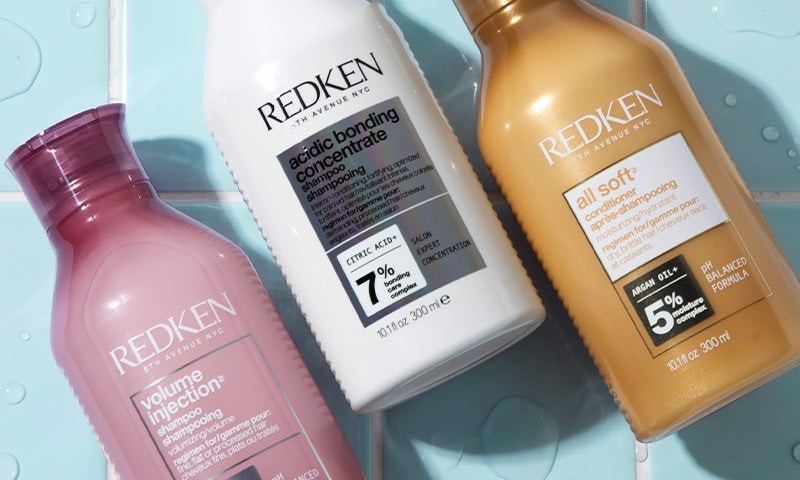 Redken hair products on blue bathroom tile