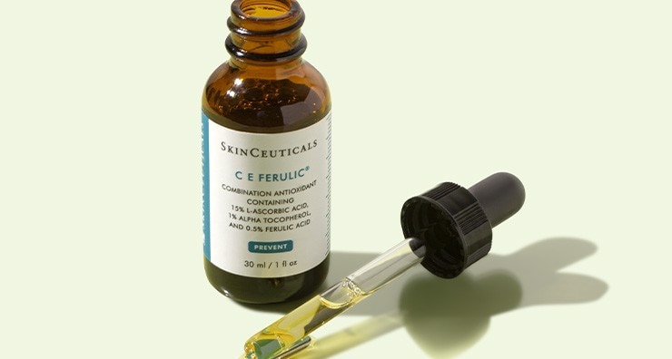 A bottle of SkinCeuticals C E Ferulic Serum with the top off on an off-white background