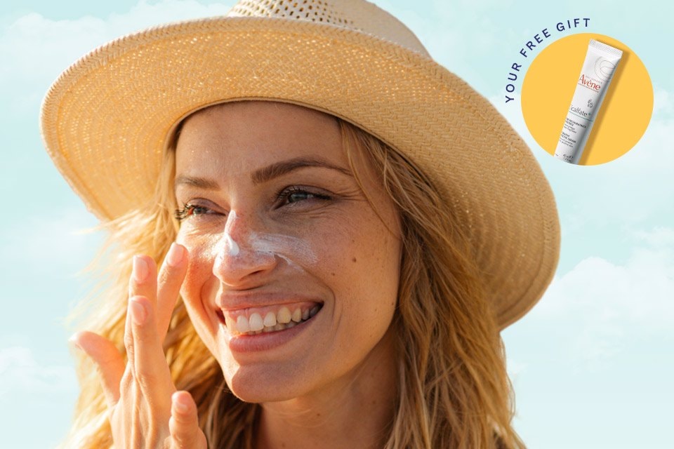 Woman applying sunscreen to her face outside