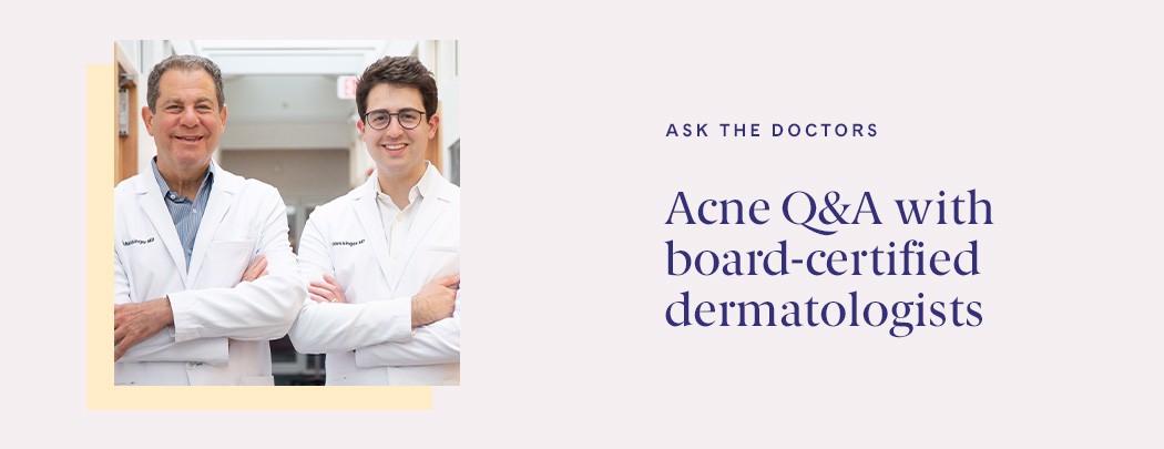 Two male dermatologists, one in his 60s and one in his 30s, stand side by side in white doctor jackets smiling.