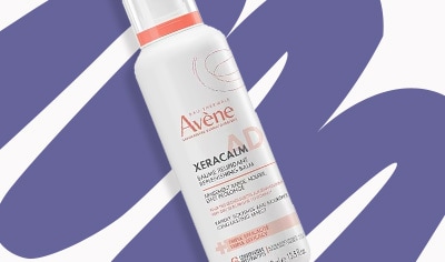A bottle of Avene XeraCalm AD Replenishing Balm lays over an illustrative purple squiggle.