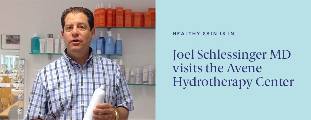 Dr. Joel Schlessinger stands over a stream while smiling.