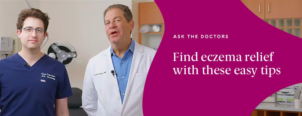 Two dermatologists stand in a clinic room next to one another.