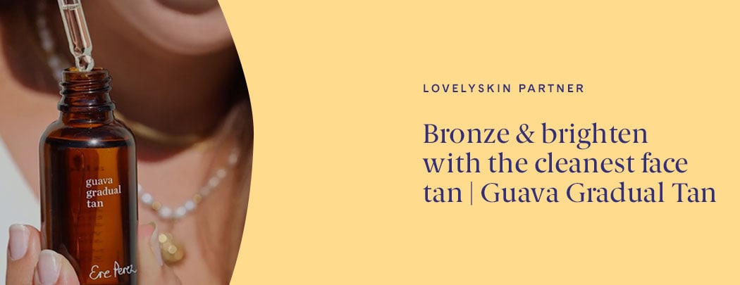 A person with a light to medium skin tone holds a bottle of Ere Perez Guava Gradual Face Tan with the dropper hovering over the open bottle.