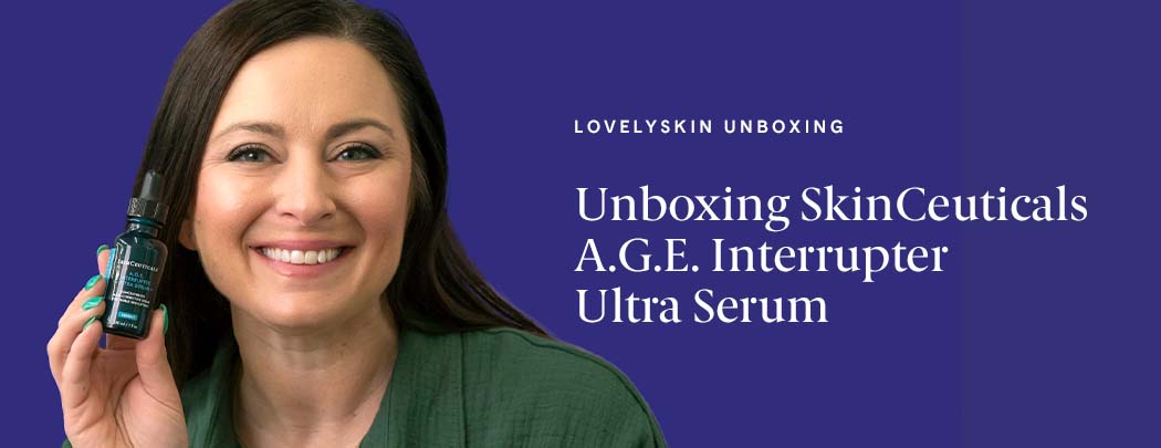 A woman with light skin and dark brown hair smiles at the camera while holding a bottle of SkinCeuticals A.G.E. Interrupter Ultra Serum.