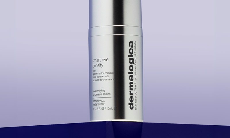 Dermalogica Smart Eye Density Serum standing on dark blue pedestal