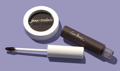 jane iredale brow powder in a round container and Ere Perez brow gel with the top lid off, on a purple background.