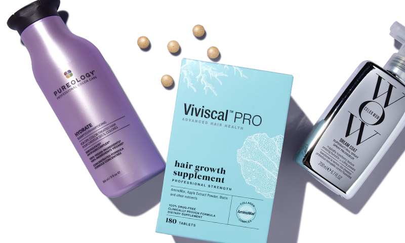 A white box of Viviscal supplements laying next to a brown jar of Moroccanoil and a clear jar of Olaplex