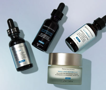 Three SkinCeuticals serums are artfully arranged over a jar of SkinCeuticals Triple Lipid Restore 2:4:2