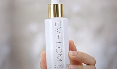 Hand holding a bottle of EVE LOM Intense Hydration Serum