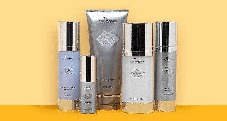 Five silver-capped containers of SkinMedica skin care products standing up against a peach. background.