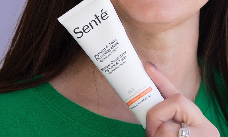 Chrissy holding product and smiling