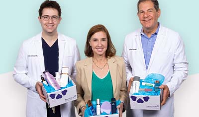 Drs. Joel and Daniel Schlessinger and Vice President Nancy Schlessinger hold LovelySkin boxes filled with products.