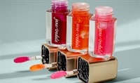 Jane Iredale Just Kissed pH Lip Oil sits open, resting on the precision applicators, showing off each of the three shades.