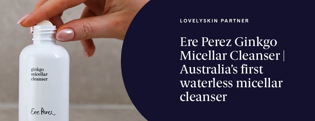 A person with a medium skin tone and chrome pink nails adds an Ere Perez Ginkgo Micellar Cleanser tablet to the white bottle.