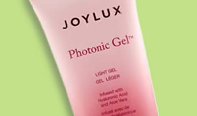 A tube of Joylux Photonic Gel™ sits over a green digital illustration.