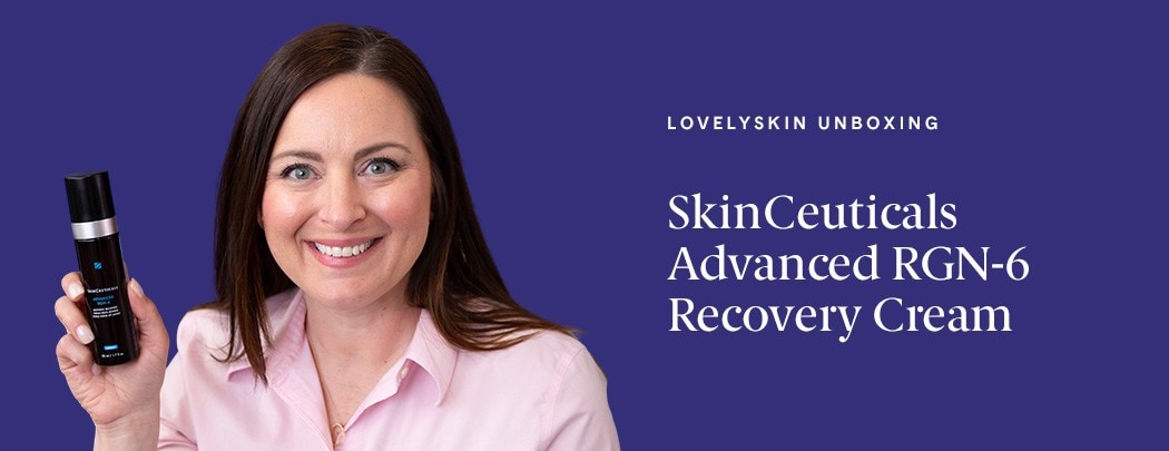 A woman with fair skin and dark hair smiles while holding a dark bottle of SkinCeuticals Advanced RGN-6. She wears a pink shirt.
