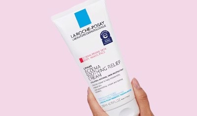 A woman's hand holds a bottle of La Roche-Posay Lipikar Eczema Cream