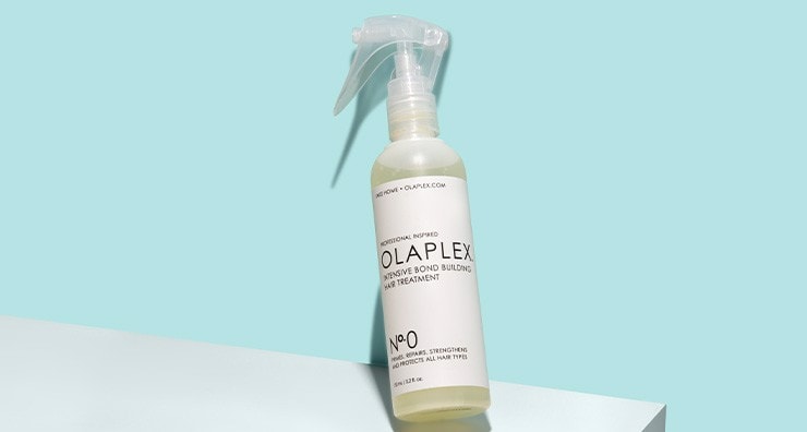 A bottle of OLAPLEX No. 0 Intensive Bond Building Treatment on a light blue background