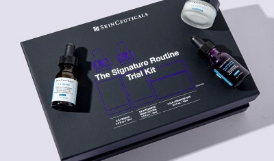 SkinCeuticals Signature Routine Trial Kit in a rectangular black box pictured slightly askew on a white background.