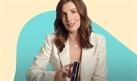 Dr. Suzan Obagi Holds a bottle of Veea Face Ultra Hydrating Moisturizing Lotion. She has medium length brown hair and is wearing a white blazer.