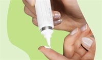 One hand dispensing retinol cream onto an index finger