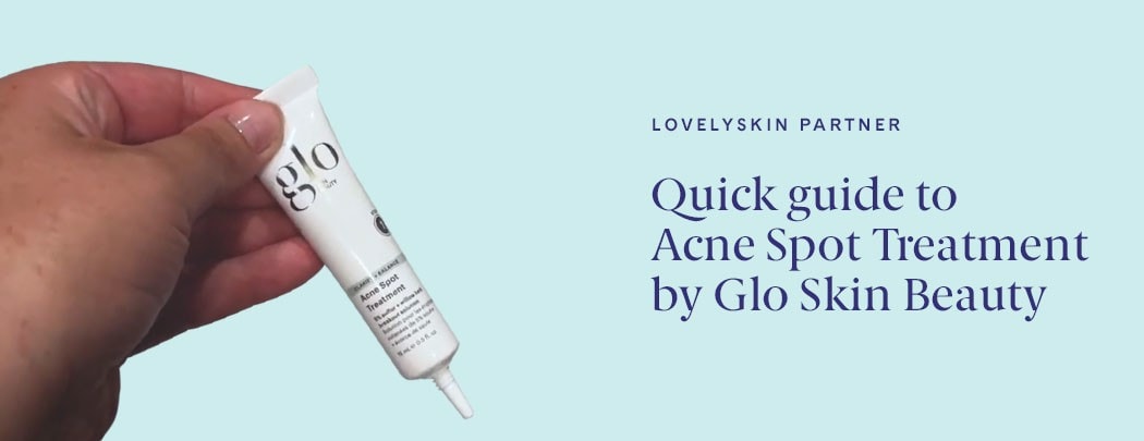 A hand holding a tube of Glo Skin Beauty Acne Spot Treatment