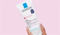 A woman's hand holds a bottle of La Roche-Posay Lipikar Eczema Cream