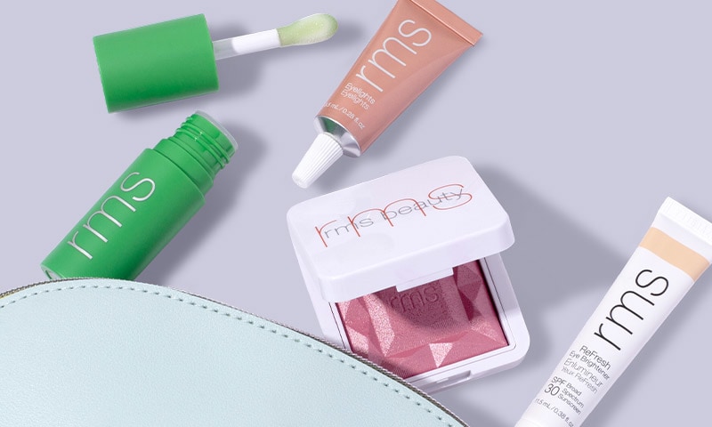 RMS Beauty products coming out of a makeup bag