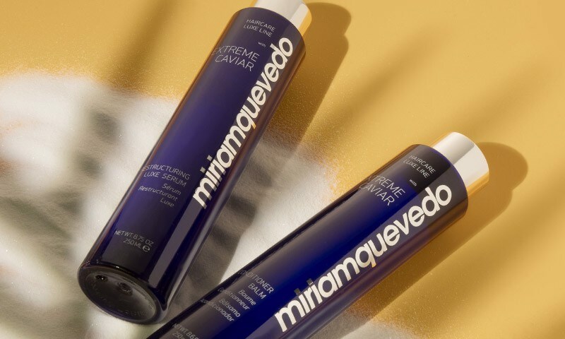 Shampoo and conditioner bottles laying on sand