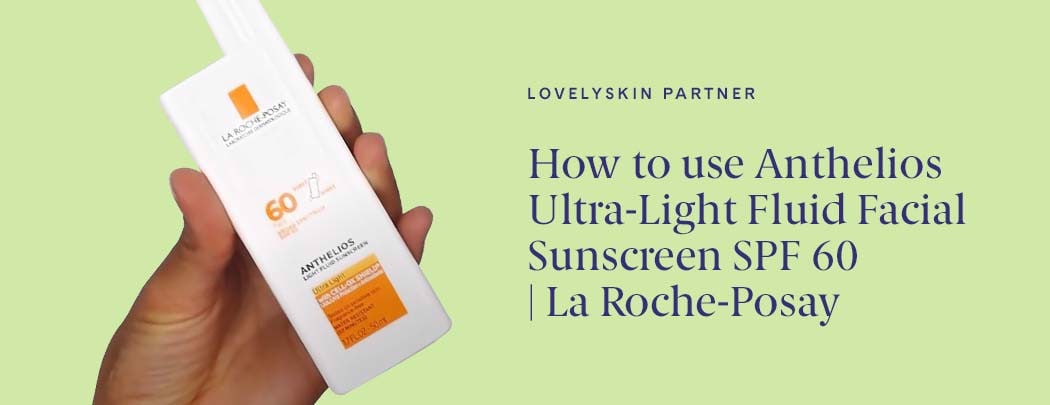 A hand with medium skin tone holds a white bottle of La Roche-Posay Anthelios 60 Ultra Light Sunscreen Fluid SPF 60