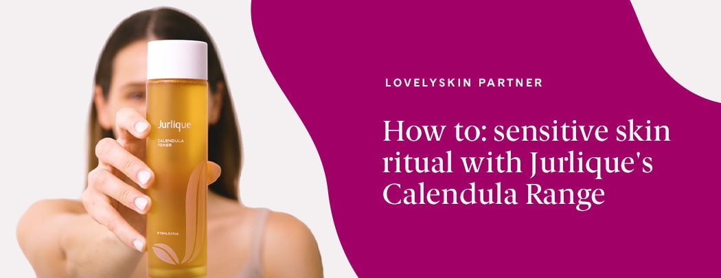 A woman with olive toned skin and brown hair holds a marigold-colored bottle of Jurlique Calendula Toner.