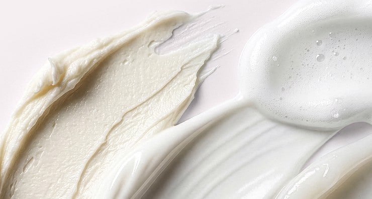 Swatches of skin care product spread across a light background, showing different textures