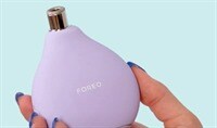 Womans hand holding the FOREO Kiwi derma device