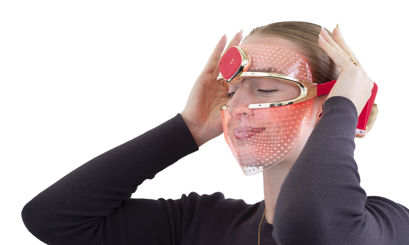 Woman using red light therapy mask